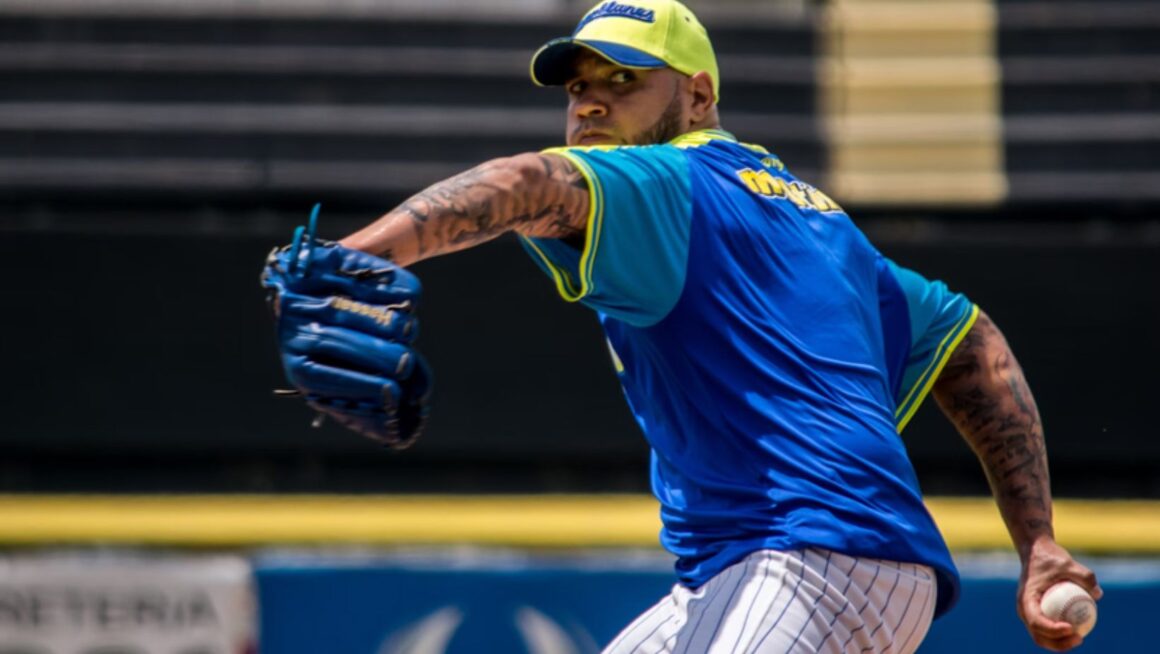 Baseball pitcher winding up to throw.