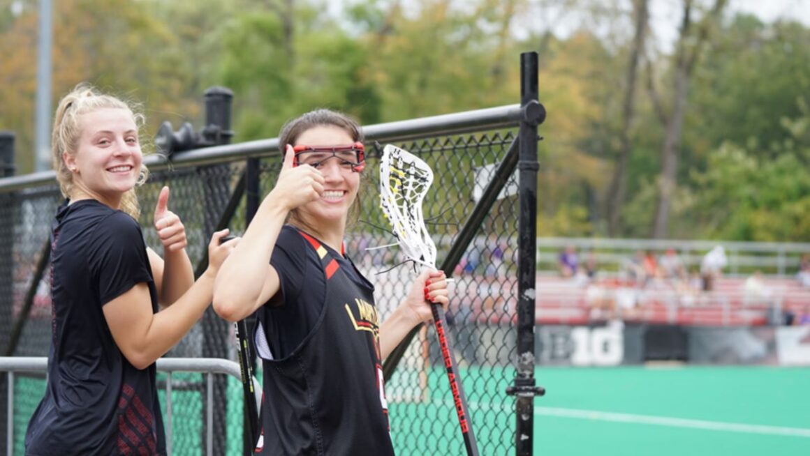 Lacrosse players giving thumbs up sideline.