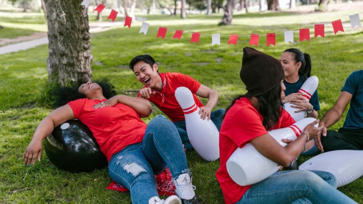 Friends laughing with inflatable bowling pins.