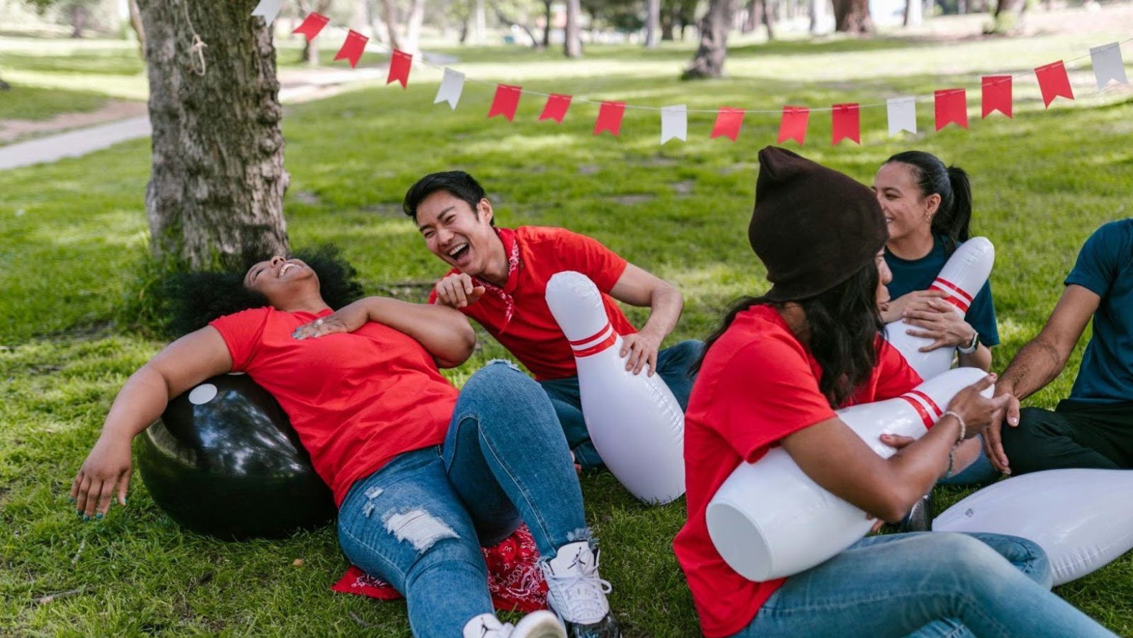 Friends laughing with inflatable bowling pins.