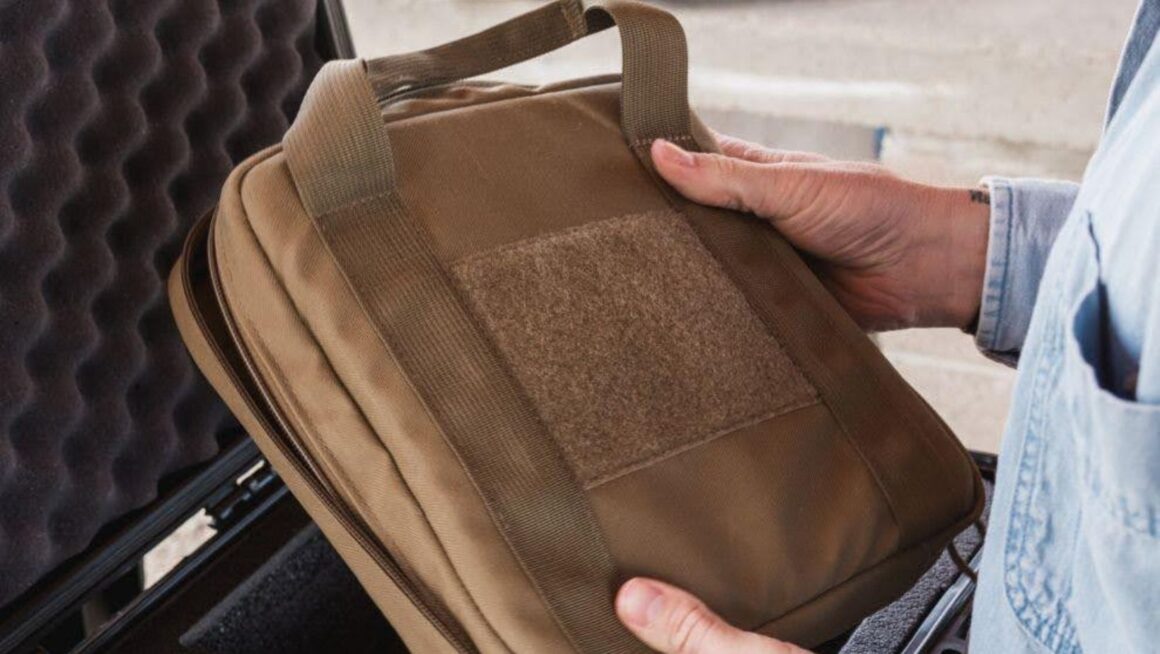 Hands holding tan pouch inside case.