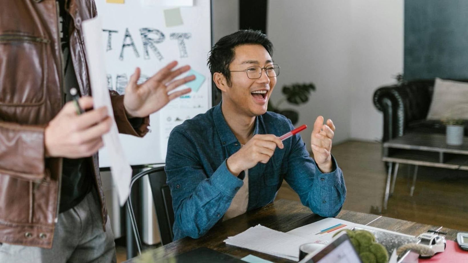 Laughing teammate during casual office meeting.
