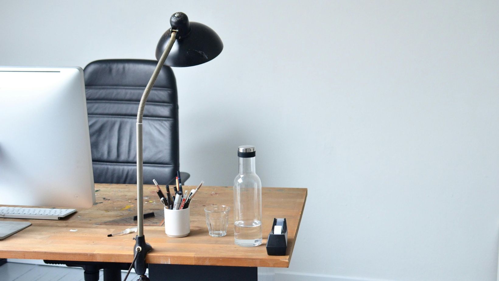 Minimalist office desk with lamp and water bottle.