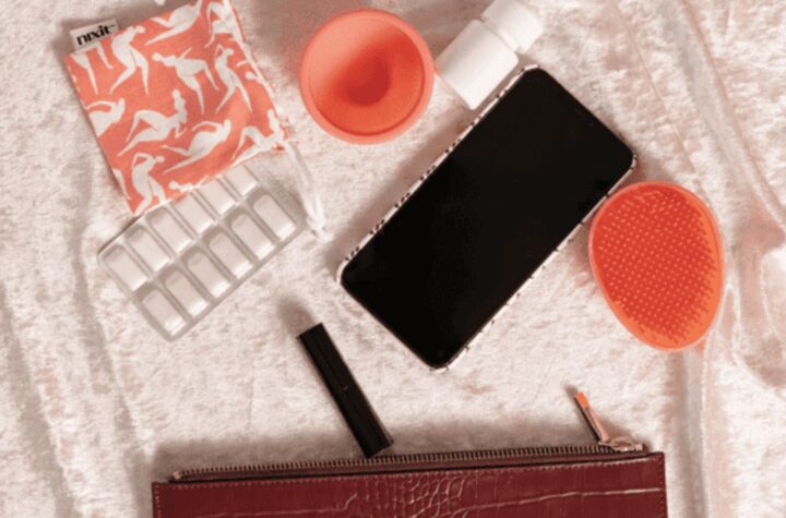 Purse essentials: phone, pills, mask, cup.