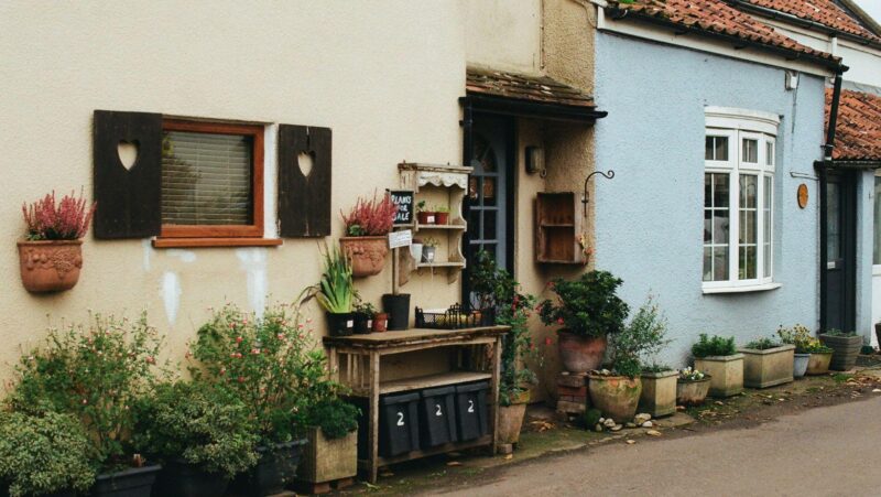 A row of terraced homes with tidy front gardens on a quiet residential street.